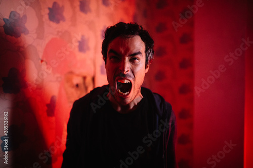 Angry man screaming at camera indoors