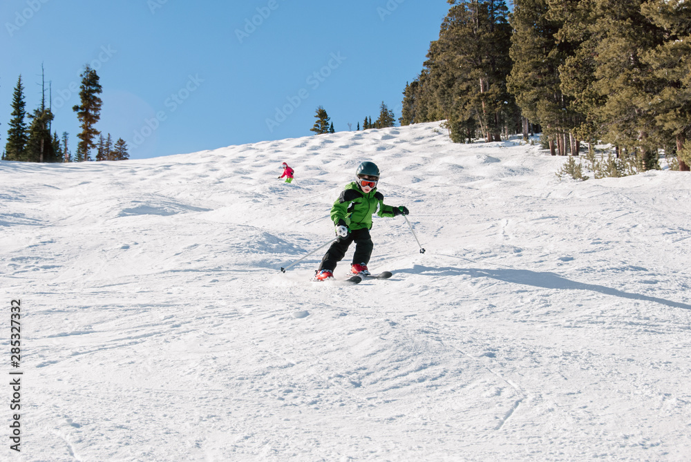 Child skiing through moguls on a sunny day in winter Child skiing through moguls on a sunny day in winter