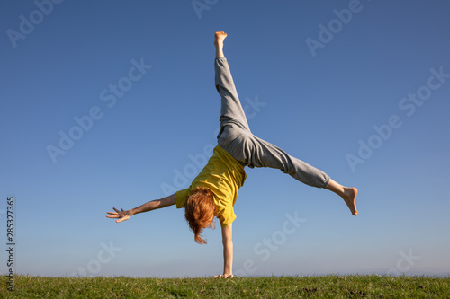 A young red-headed doing a cartwheel.
