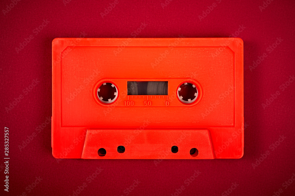 Fototapeta premium orange audio cassette on the dark red background