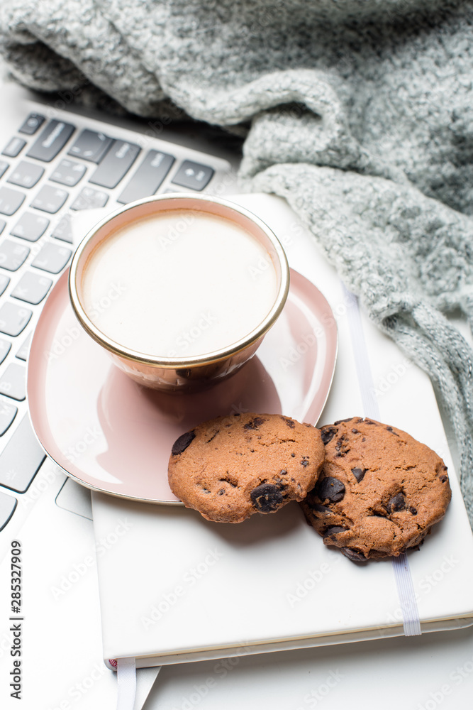 Beautiful enameled pink cup of coffee with blanket and laptop Beautiful enameled pink cup of coffee with blanket and laptop