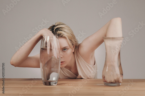Woman holding hands in vases with water photo