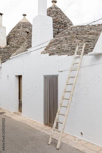 Ladder leaning against a trullo, typical building in the village of Alberobello photo