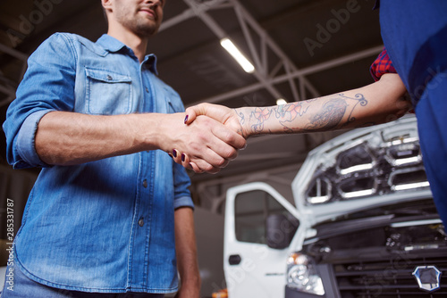 Car owner shakes mechanics hand as the gratefull gesture.