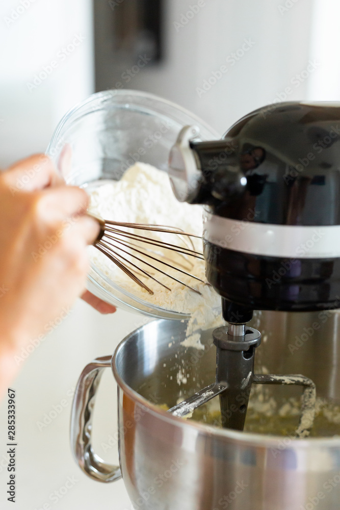 Adding flour into stand mixer, cake batter mixing