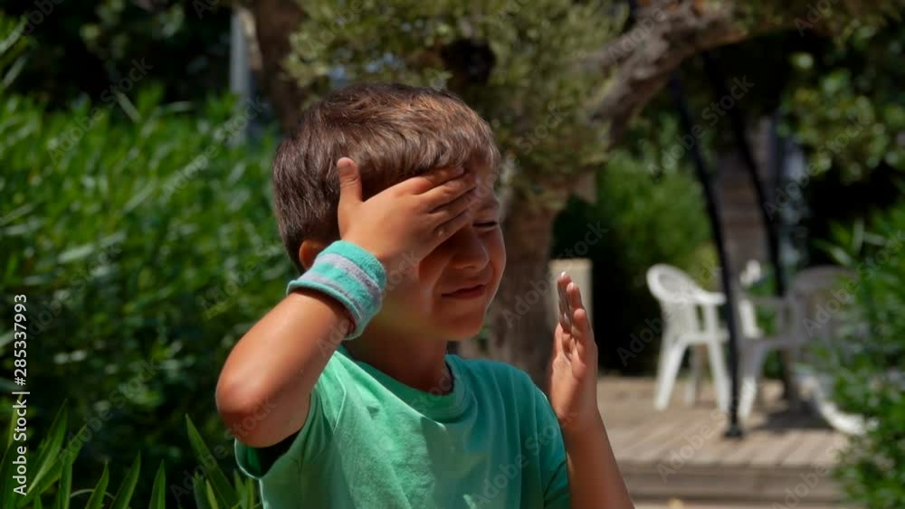 Little boy smears his face with sun protection cream Little boy smears his face with sun protection cream