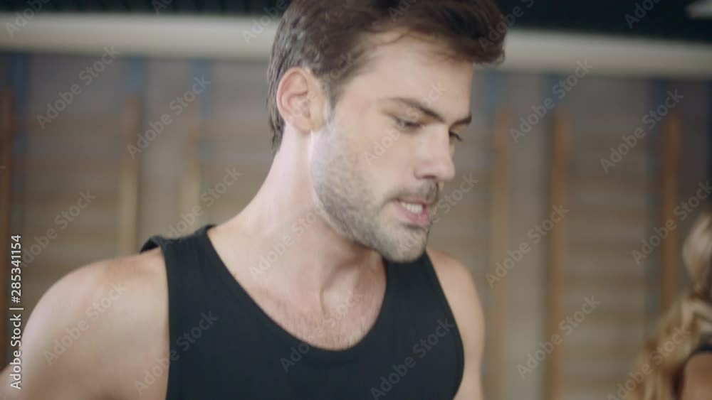 Portrait of handsome man running on treadmill machine in fitness club. Closeup Portrait of handsome man running on treadmill machine in fitness club. Closeup