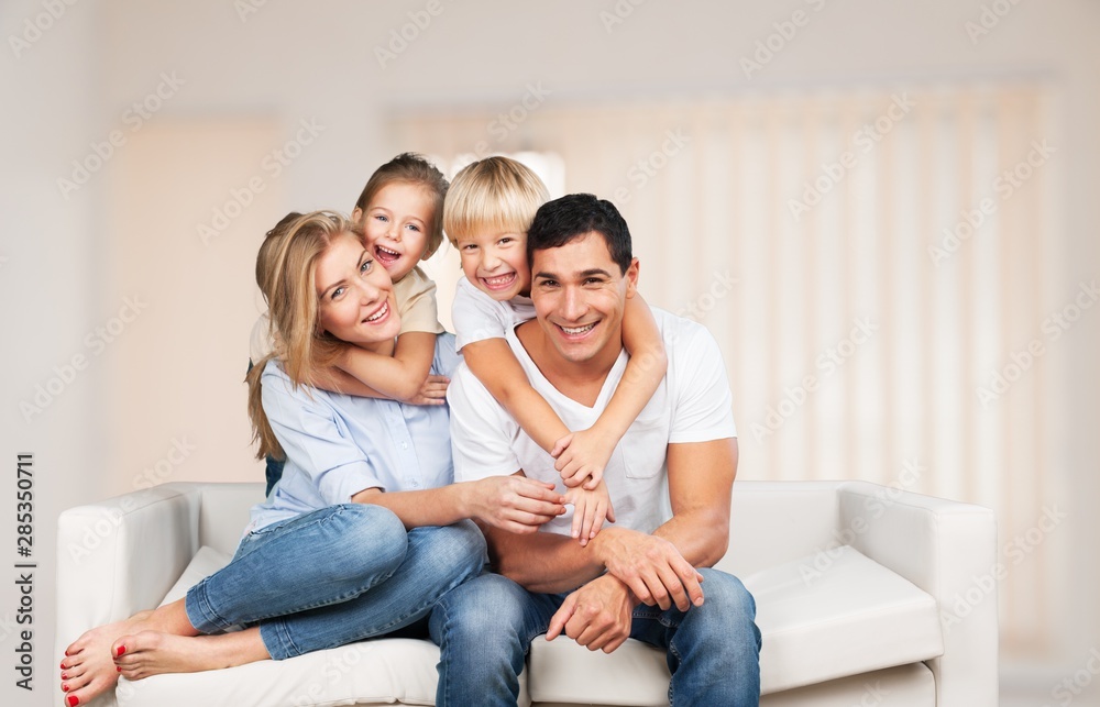 Beautiful smiling family sitting at sofa at home