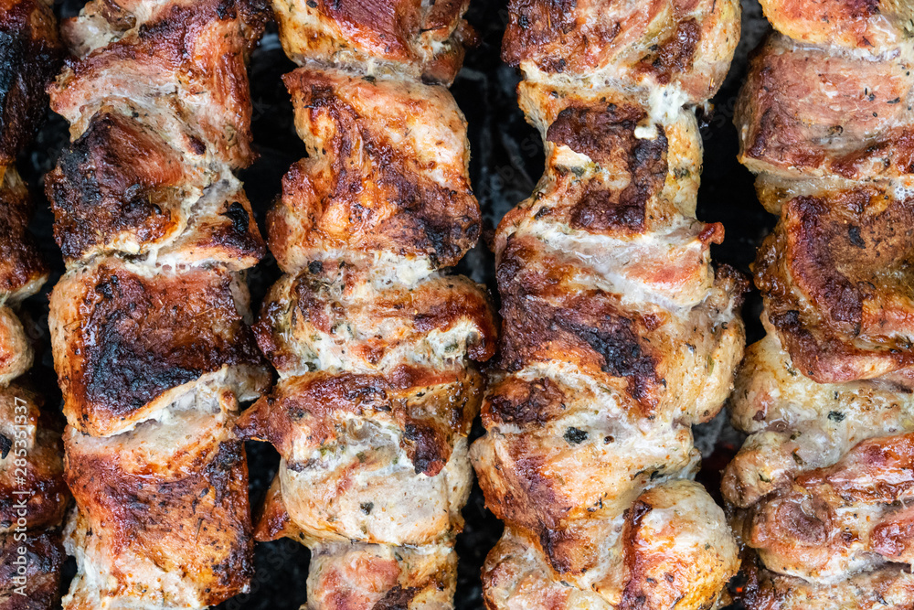 Frying pork on a skewer over a brazier. Turning meat over coals. Appetizing shish kebab. Frying pork on a skewer over a brazier. Turning meat over coals. Appetizing shish kebab.