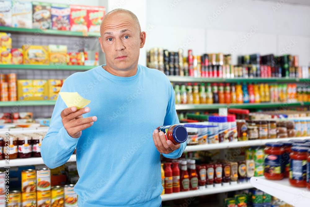 Focused man choosing fresh products during shopping at food store