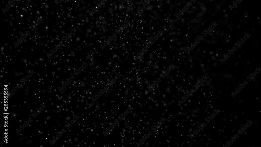 Flight of the Cosmic Dust. Small white particles flow in the air on a black background to simulate snow, blizzard, or a microcosm of the Christmas magic. Filmed at a speed of 120fps Flight of the Cosmic Dust. Small white particles flow in the air on a black background to simulate snow, blizzard, or a microcosm of the Christmas magic. Filmed at a speed of 120fps