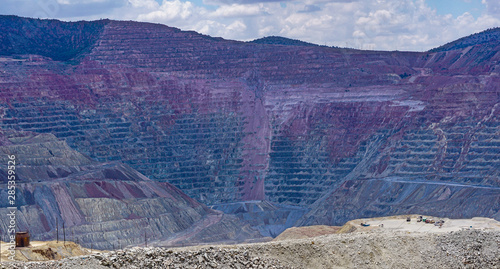 View of Chino open pit copper mine in Santa Rita, New Mexico, east of Silver City. Vehicles in right foreground show scale of the mile-wide excavation.