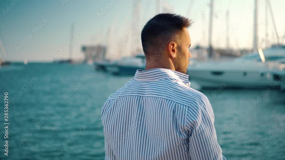 Young rich man at Yacht Club. Businessman is Relaxing in the gulf with seaview and luxury ships Young rich man at Yacht Club. Businessman is Relaxing in the gulf with seaview and luxury ships