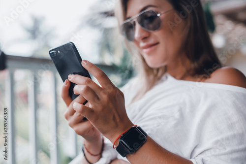 young pretty woman posing in the street with phone, outdoor portrait, hipster girls, sisters, chic, tablet, internet, using smartphone, close-up fashion model, post in instagram, facebook