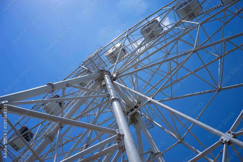 Obraz premium Beautiful and modern Ferris wheel on blue sky background.
