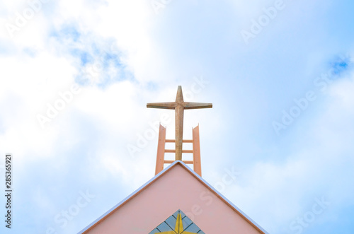 Cross on a church roof, white clouds and blue sky in bacground. photo