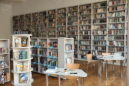 Blurred view of bookshelves and tables in library