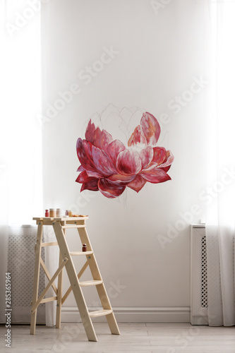 Unfinished flower painting on white wall in room. Interior design photo