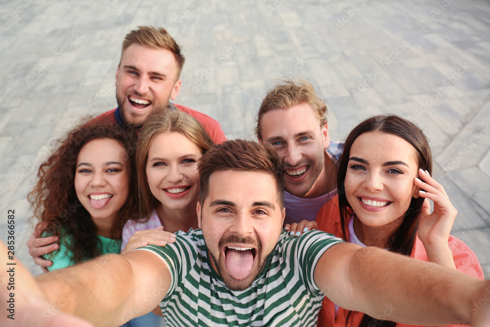 Obraz premium Happy young people taking selfie outdoors on sunny day