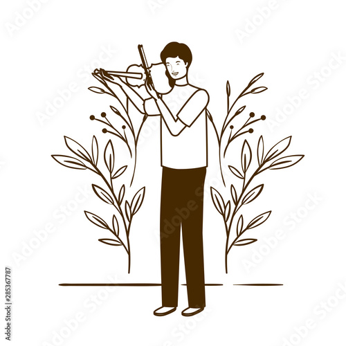 silhouette of man with fiddle and branches and leaves in the background