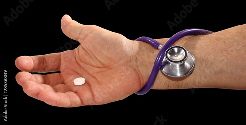 palm of man pill and stetskop, patient heart pressure concept isolated on black background, medicine