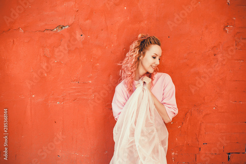 Young brunette girl in black standing outside and watching the sunset in the city, the sun shines brightly, fashionable clothes on a girl, hipster style,tattoo, street photo, mood, freedom, New York