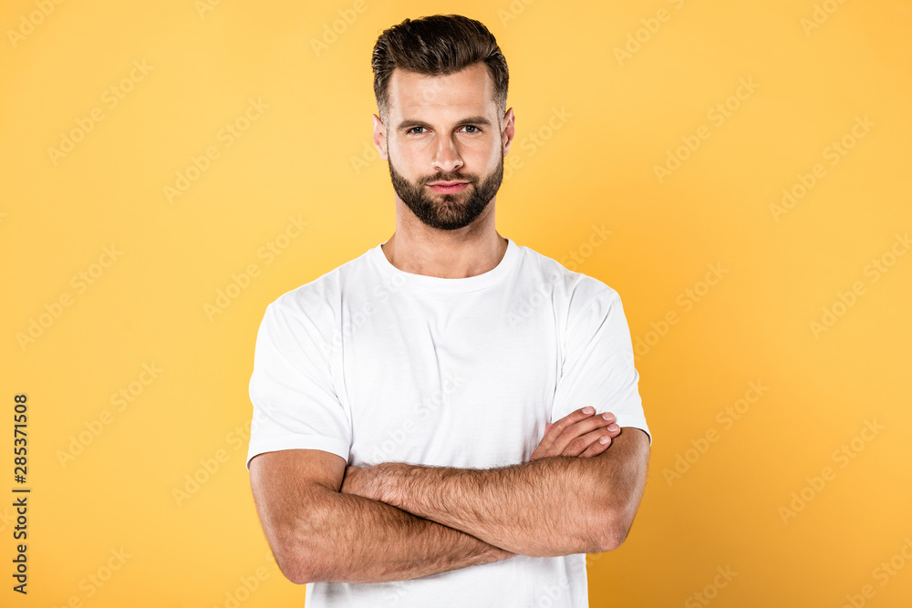 handsome man in white t-shirt with crossed arms isolated on yellow handsome man in white t-shirt with crossed arms isolated on yellow