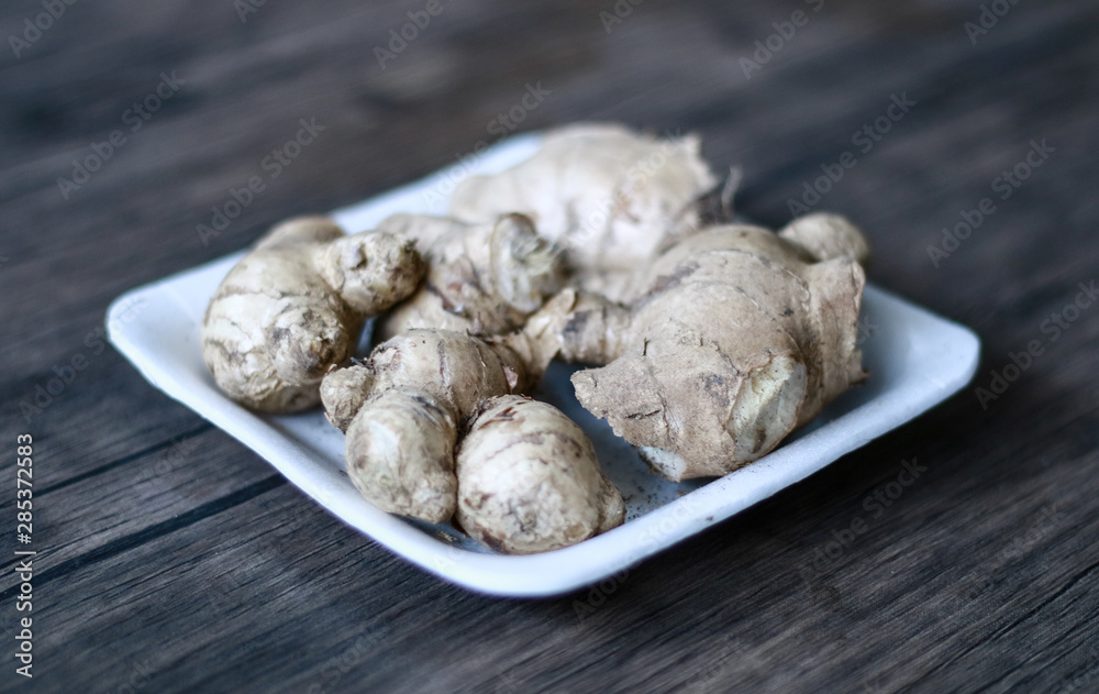 Ginger or Zingiber officinale on wood background. Used as a spice and a folk medicine.
