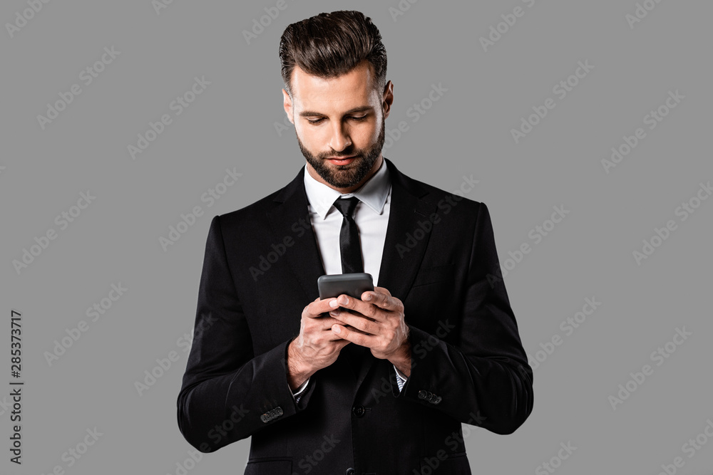 bearded businessman in black suit using smartphone isolated on grey bearded businessman in black suit using smartphone isolated on grey