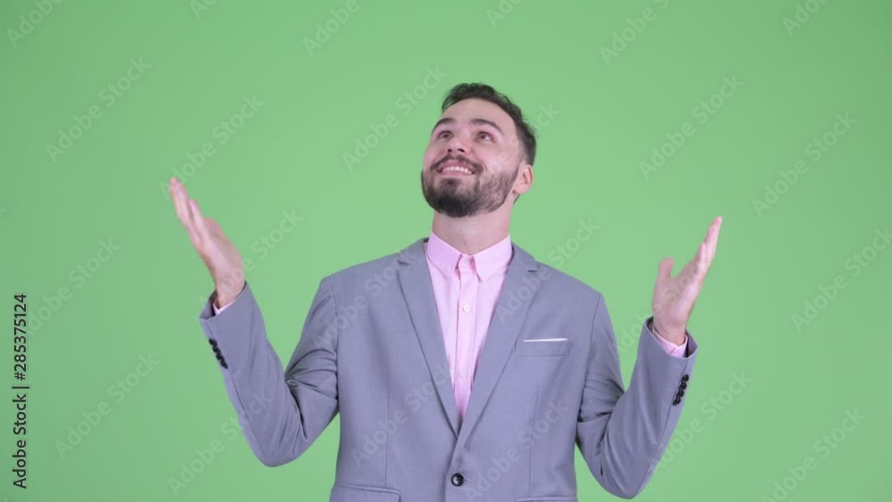 Happy young bearded businessman catching something Happy young bearded businessman catching something