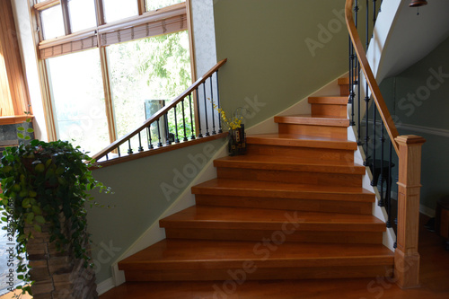Wooden interior stairway of luxury residential house with railings.