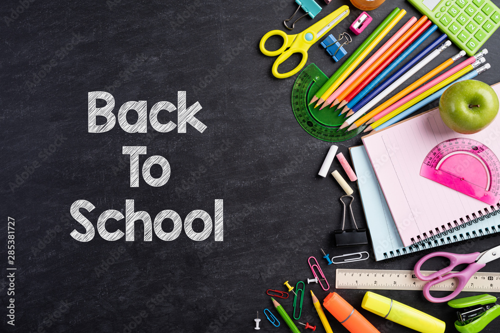 Education or back to school Concept. Top view of Colorful school supplies with books, color pencils, calculator, pen cutter clips and green apple on chalkboard background. Flat lay. Education or back to school Concept. Top view of Colorful school supplies with books, color pencils, calculator, pen cutter clips and green apple on chalkboard background. Flat lay.