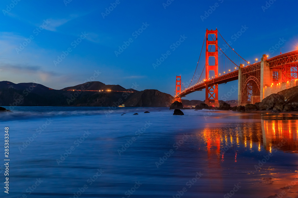 Naklejka premium Golden Gate Bridge view from the hidden and secluded rocky Marshall's Beach at sunset in San Francisco, California