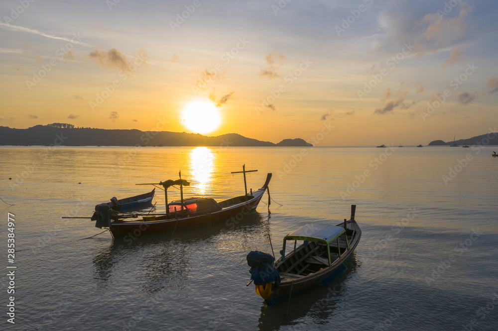 Fototapeta premium aerial view sunrise above fishing boats parking near the beach.