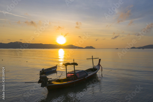 aerial view sunrise above fishing boats parking near the beach. © Narong Niemhom