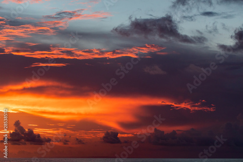 Majestic colorful tropical sunset. Amazing red, orange, pink clouds. Tropical background.