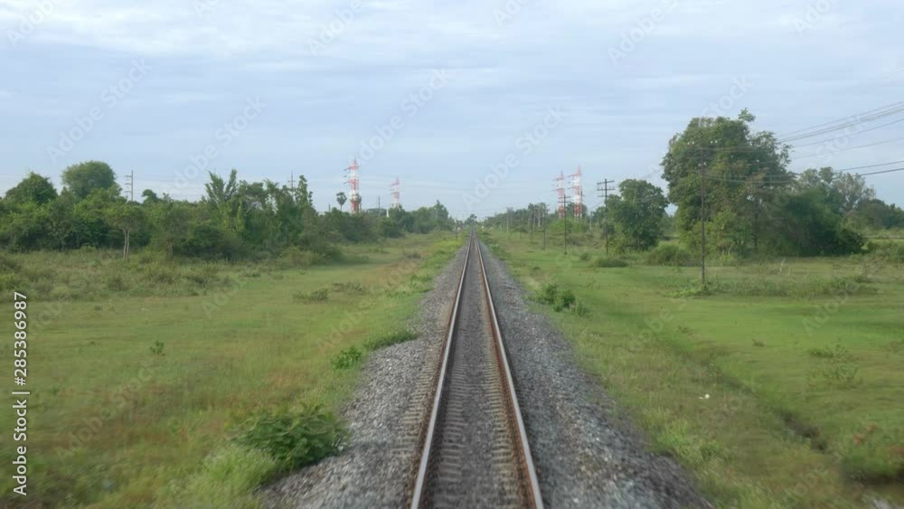 Single railroad track seen from back of train crossing lush green area, tracking shot Single railroad track seen from back of train crossing lush green area, tracking shot
