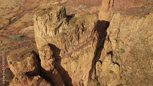 Tilting drone shot of steep mountain cliff, location of small monolithic church of Abuna Yemata Guh in the Tigray region of Ethiopia photo