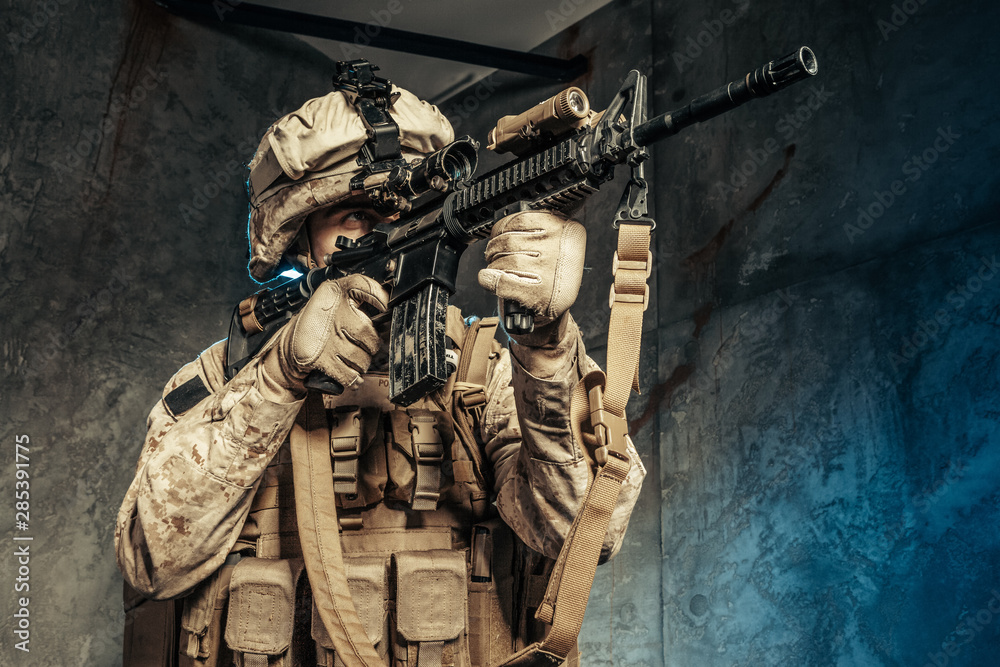 Obraz premium American private military contractor shooting a rifle. Studio shot
