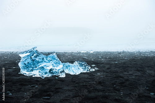 Blue ice on the Jokulsarlon ice beach at foggy day, southern Iceland.