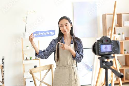 Female Asian blogger recording video in workshop