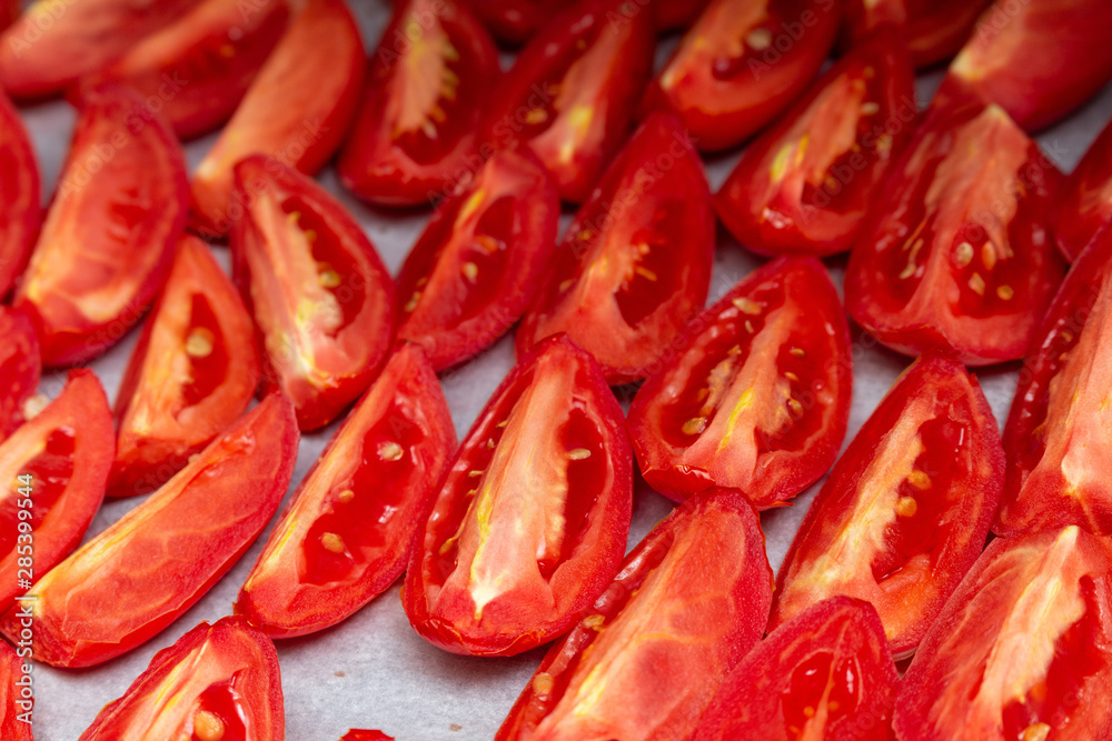Homemade dried red tomatoes slices with basil oregano spices cooking process. Traditional Italian Mediterranean kitchen cuisine. Homemade dried red tomatoes slices with basil oregano spices cooking process. Traditional Italian Mediterranean kitchen cuisine.
