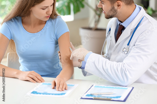Doctor vaccinating young wo...