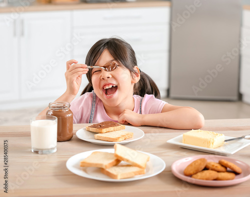 Funny little girl eating ta...