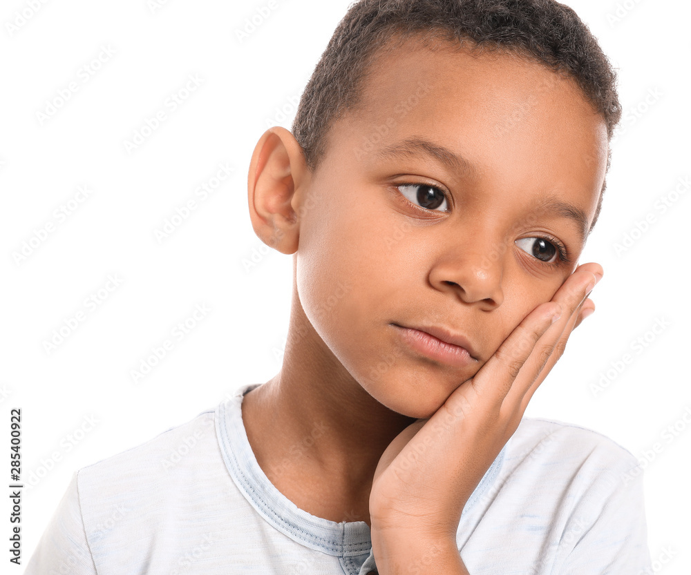 Little African-American boy suffering from toothache against white background