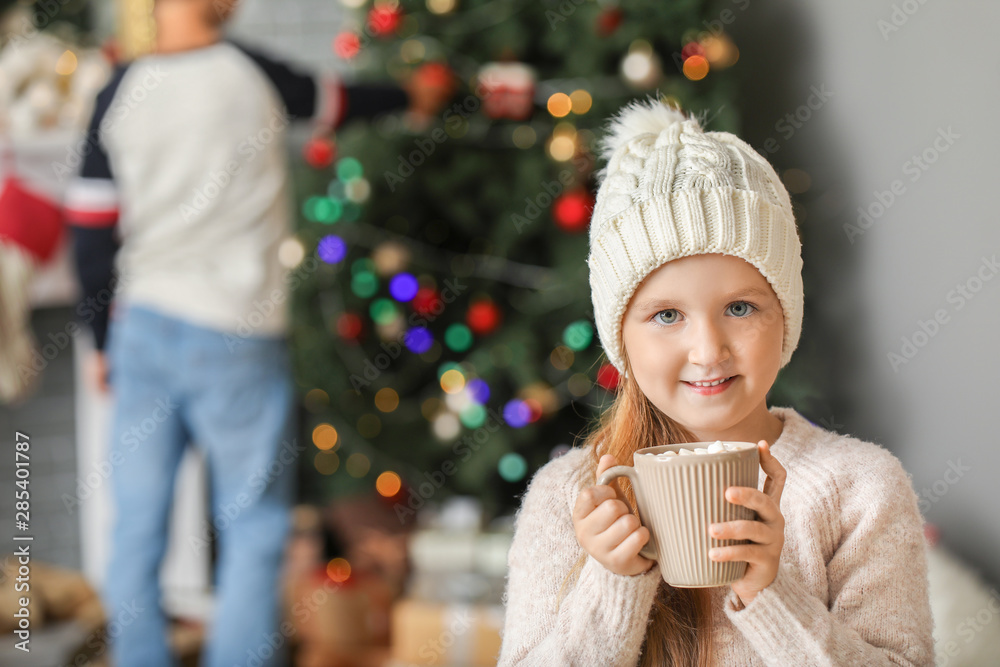 Cute little girl drinking hot chocolate at home on Christmas eve Cute little girl drinking hot chocolate at home on Christmas eve