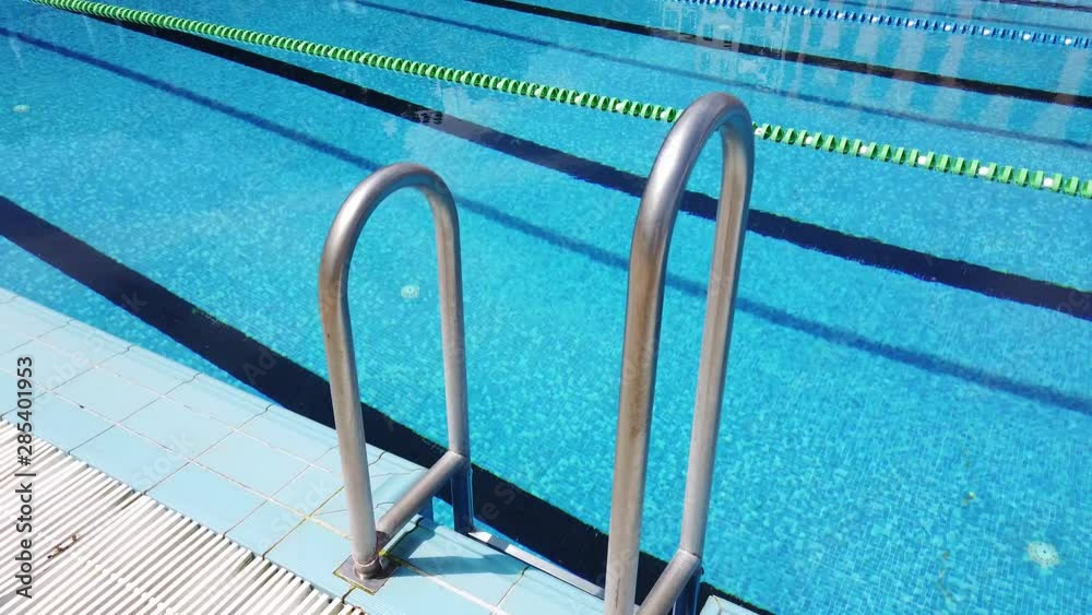 Swimming pool with pool ladder. Handrails to stairs leading to swimming pool Swimming pool with pool ladder. Handrails to stairs leading to swimming pool