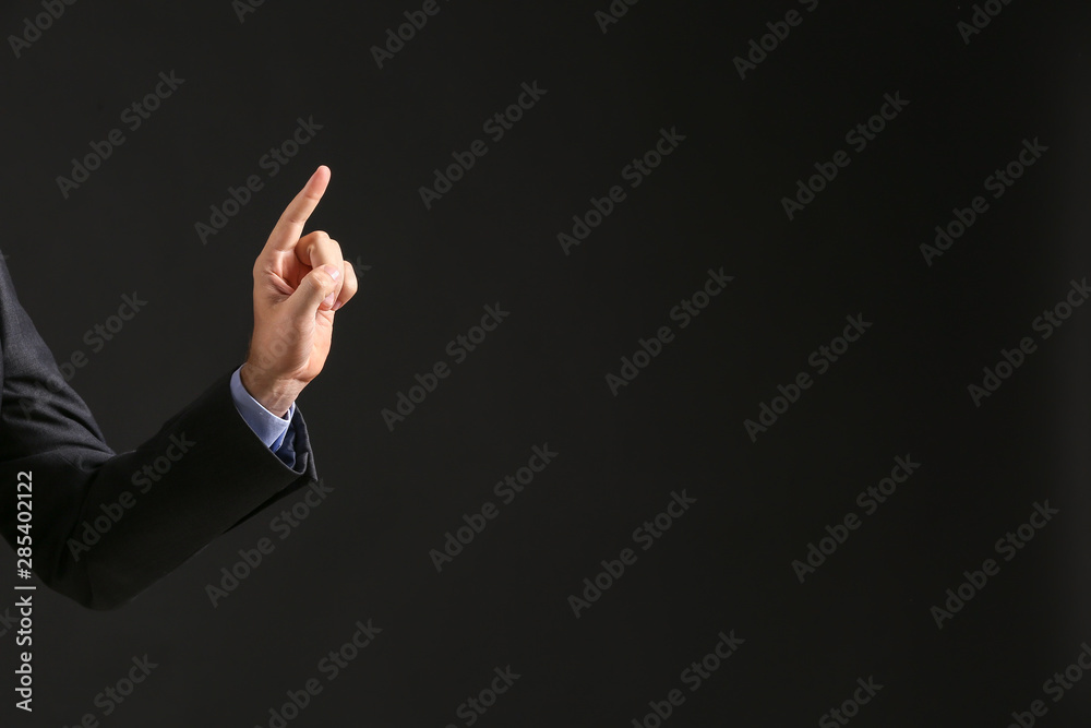Hand of businessman on dark background Hand of businessman on dark background