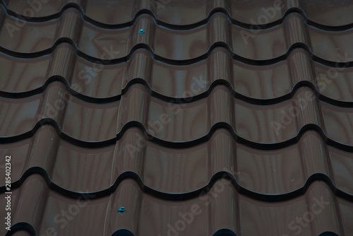 Overlapped shining brown tiles of a building roof