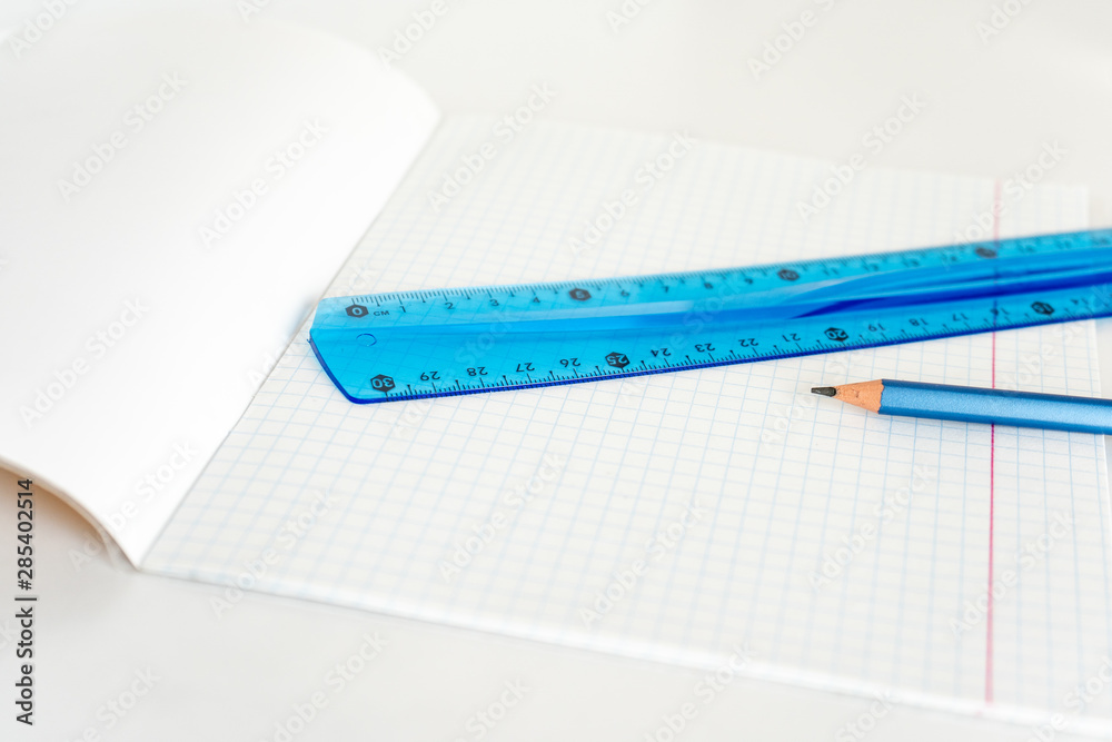 open school notebook with a simple pencil and a ruler on a white table. back to school open school notebook with a simple pencil and a ruler on a white table. back to school